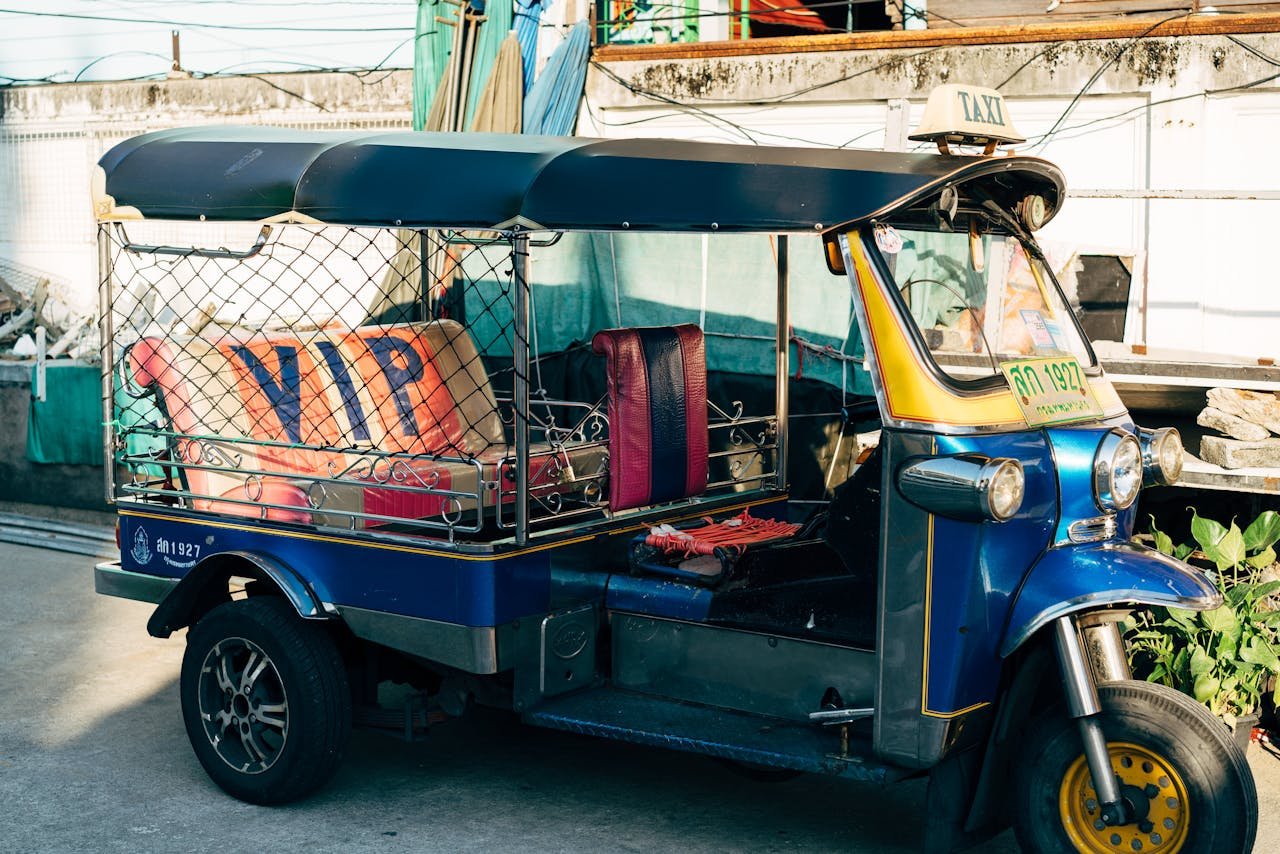 Colorful tuk tuk taxi parked on a bustling street in Bangkok, Thailand, capturing urban culture.